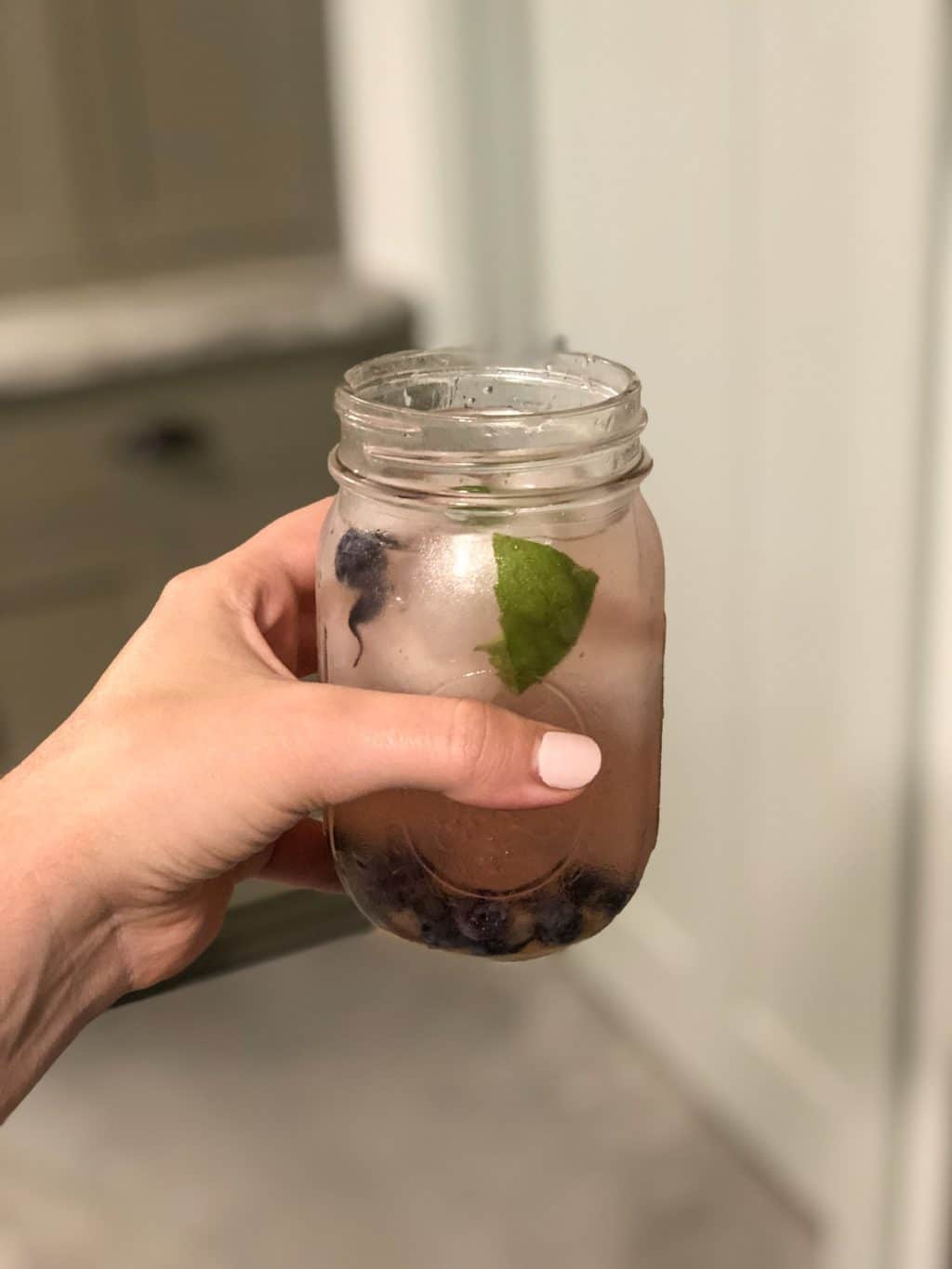 hand holding blueberry basil cocktail