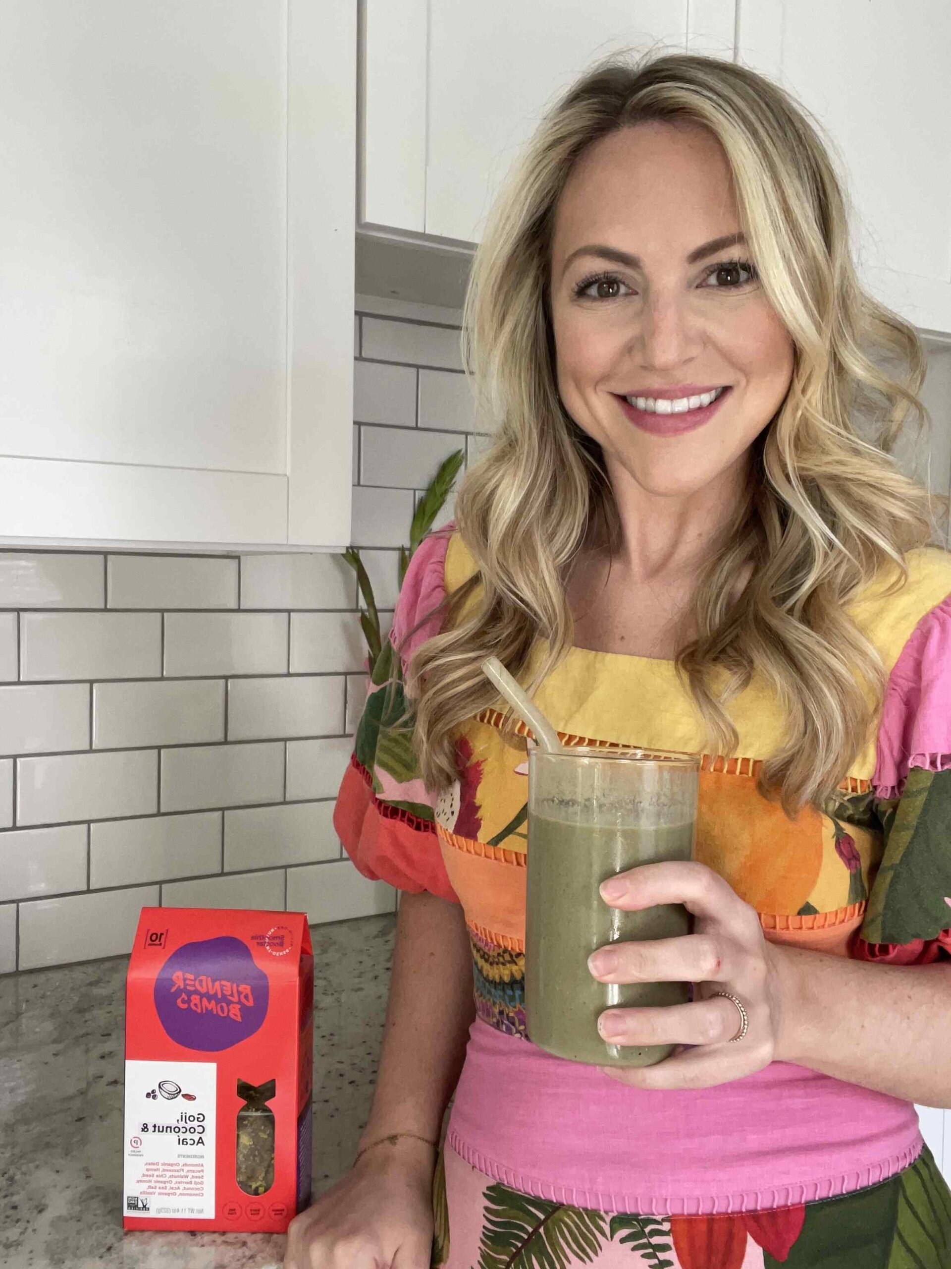 Blonde dietitian smiling holding a smoothie